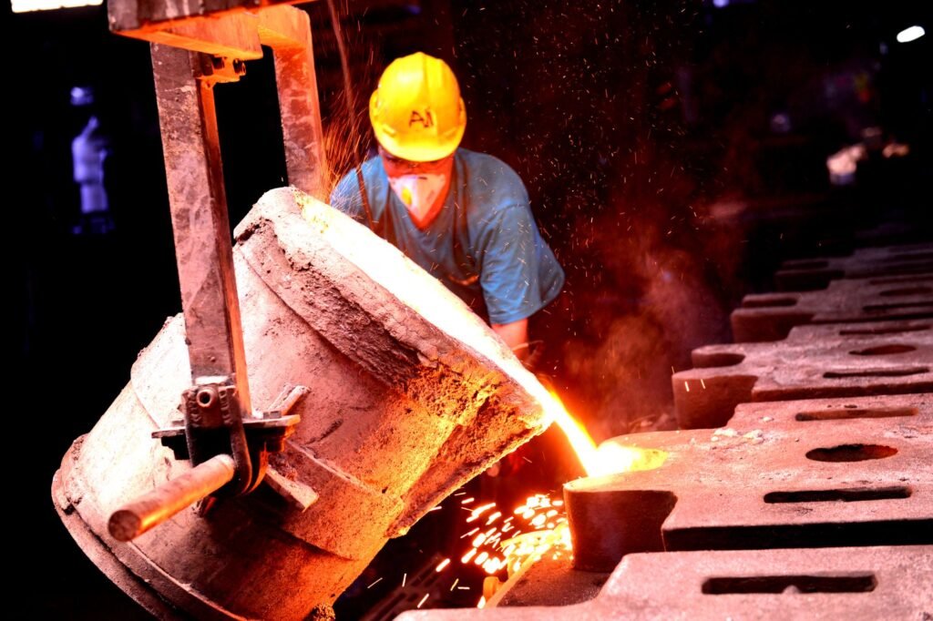 Foundry worker pouring molten metal